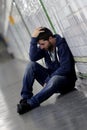 Young sick man lost suffering depression sitting on ground street subway tunnel