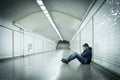 Young sick man lost suffering depression sitting on ground street subway tunnel Royalty Free Stock Photo