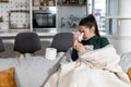 Young sick stressed woman lying at home covered with blanket blowing her nose. Ill female have common cold and flue with runny nos Royalty Free Stock Photo