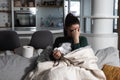 Young sick stressed woman lying at home covered with blanket blowing her nose. Ill female have common cold and flue with runny nos Royalty Free Stock Photo