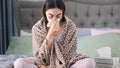 Young sick woman blowing her nose while in bed Royalty Free Stock Photo