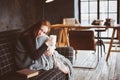 Young sick woman healing with hot drink at home on cozy couch