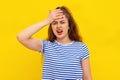 Young sick woman touching her head, has unbearable headache suffers from migraine, dressed in white-blue striped t shirt. Indoor Royalty Free Stock Photo