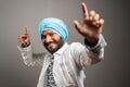 Young sikh man Balle balle Gurmukhi style indian cultural dancing on studio background - concept of happiness and relaxation