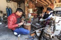 Young silversmith working on his workshop along with another woman dressed with the traditional Bai attire. Royalty Free Stock Photo