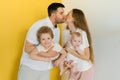 Young sincere family, where a happy father and mother hold their baby son in their arms and kiss Royalty Free Stock Photo