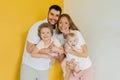 Young sincere family, where a happy father and mother hold their lovely children in their arms. Family photo shoot in the studio Royalty Free Stock Photo