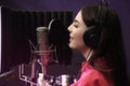Young singer with microphone recording song