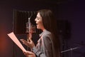 Young singer with microphone recording song