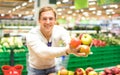 Young single man showing fruit and vegetables at shopping in grocery store supermarket - Modern healthy lifestyle concept concept