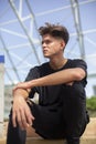 Young skateboarder with black t-shirt and street and blue sky background