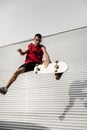 Young skateboarder jumps up with his board in front of a metal b Royalty Free Stock Photo