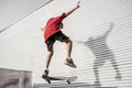 Young skateboarder jumps up with his board in front of a metal b Royalty Free Stock Photo