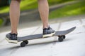 Young skateboarder legs riding skateboard at skatepark Royalty Free Stock Photo