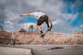 Young skateboarder man does a trick called nose grab in the pool of a skate park Royalty Free Stock Photo