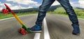 A young skateboarder in sneakers and jeans, standing on his skate. Closeup fragment of the skateboard and feet.