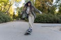 Young skateboarder woman practicing tricks with a longboard outdoors in a park. Royalty Free Stock Photo