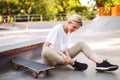 Young skater girl holding her painful leg with skateboard near at skatepark Royalty Free Stock Photo