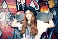 Young skater girl holding her skate in an urban place Royalty Free Stock Photo