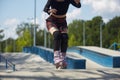 Young skater girl riding in a skatepark. Aggressive inline roller blader female skating in a outdoor concrete park