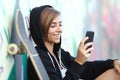 Young skater happy teen girl using a smart phone