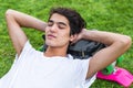 Young male skater resting on the grass with his eyes closed. Royalty Free Stock Photo