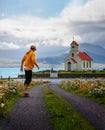 Young skater skateboarding towards a church and a cemetery in Iceland