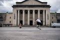 Young skater skating near the Guildhall Museum under a cloudy sky in Southampton, the UK