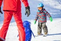 Young skier sliding down towards towards toy penguin and ski ins Royalty Free Stock Photo