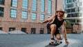Young skilful skater performing with longboard at sunset in urban city street