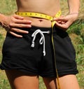 skinny girl measuring her waist with a yellow measuring tape Royalty Free Stock Photo