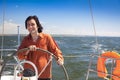 Young skipper driving sailboat