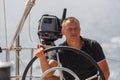 A young skipper at the helm of a sailing ship. Sport.