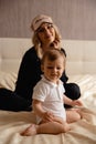 Young Sleeping Beuty blonde woman wearing blindfold sleep mask sitting on her bedroom bed going to bed - Wearing black Royalty Free Stock Photo