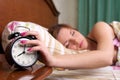 Young sleeping female turns alarm