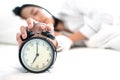 Young sleeping woman and alarm clock in bedroom Royalty Free Stock Photo