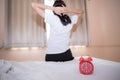 Young sleeping woman and alarm clock in bedroom Royalty Free Stock Photo