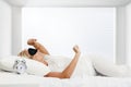 Young sleeping woman and alarm clock in bedroom at home Royalty Free Stock Photo