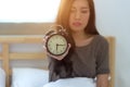 Young sleeping woman and alarm clock in bedroom