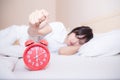 Young sleeping woman and alarm clock in bedroom Royalty Free Stock Photo