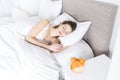 Young sleeping woman and alarm clock in bedroom at home Royalty Free Stock Photo