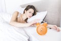 Young sleeping woman and alarm clock in bedroom at home Royalty Free Stock Photo