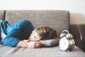 Young sleeping woman and alarm clock in bedroom at home. Royalty Free Stock Photo