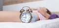 Young sleeping woman and alarm clock in bedroom Royalty Free Stock Photo