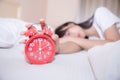 Young sleeping woman and alarm clock in bedroom Royalty Free Stock Photo