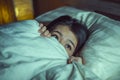 Young sleepless beautiful and scared Asian Chinese woman lying on bed awake at night suffering nightmare after watching zombie Royalty Free Stock Photo