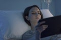 Young sleepless patient at the hospital connecting with a tablet