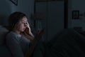 Young sleepy exhausted woman lying in bed using smartphone and touching her forehead, can not sleep. Insomnia, nomophobia, sleep Royalty Free Stock Photo