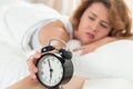 Young sleepy woman trying to turn off the alarm clock Royalty Free Stock Photo