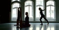 Young slender blonde girl dancer is in a large Studio with large Windows, she approaches the Gong with dancing movements